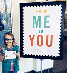 Girl Scout Alexis Flanagan holds her letter to PMG Megan Brennan.