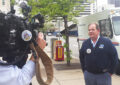 A TV news crew interviews Denver Letter Carrier Jeff Frey, a food drive coordinator.