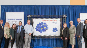 Participants gather on stage following the stamp’s unveiling.