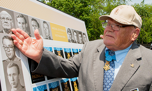 Retired Army Command Sgt. Maj. Bennie Adkins points to his picture