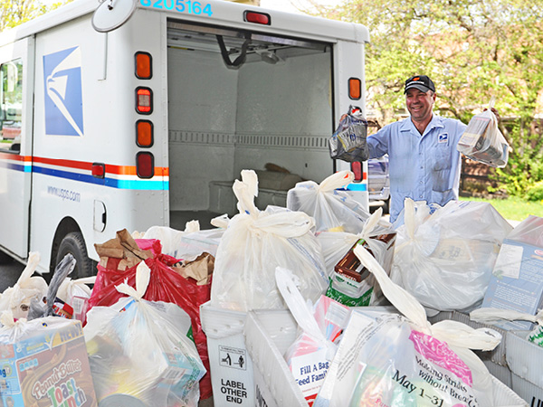Canajoharie, NY, City Carrier Assistant Dave Diodato collects food during the 2014 Stamp Out Hunger.