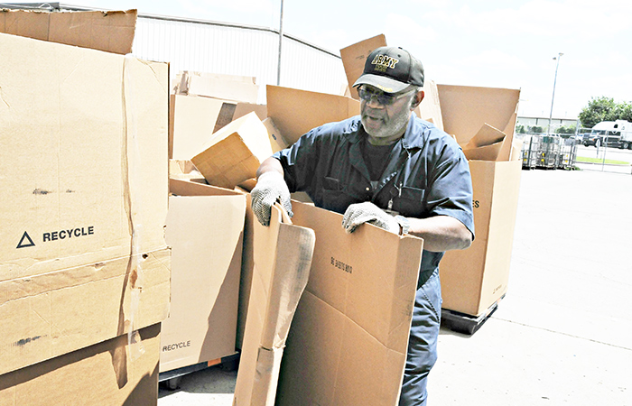 Employee recycling cardboard waste