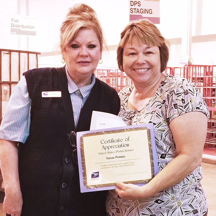 Employee receives certificate from Postmaster