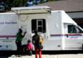 Customers pick up their mail at a mobile postal unit in Eastover.