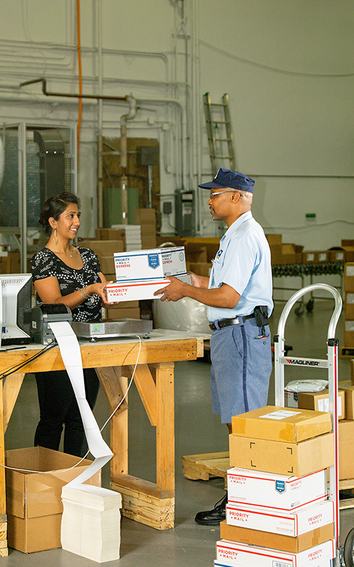 A letter carrier delivers packages to a customer.
