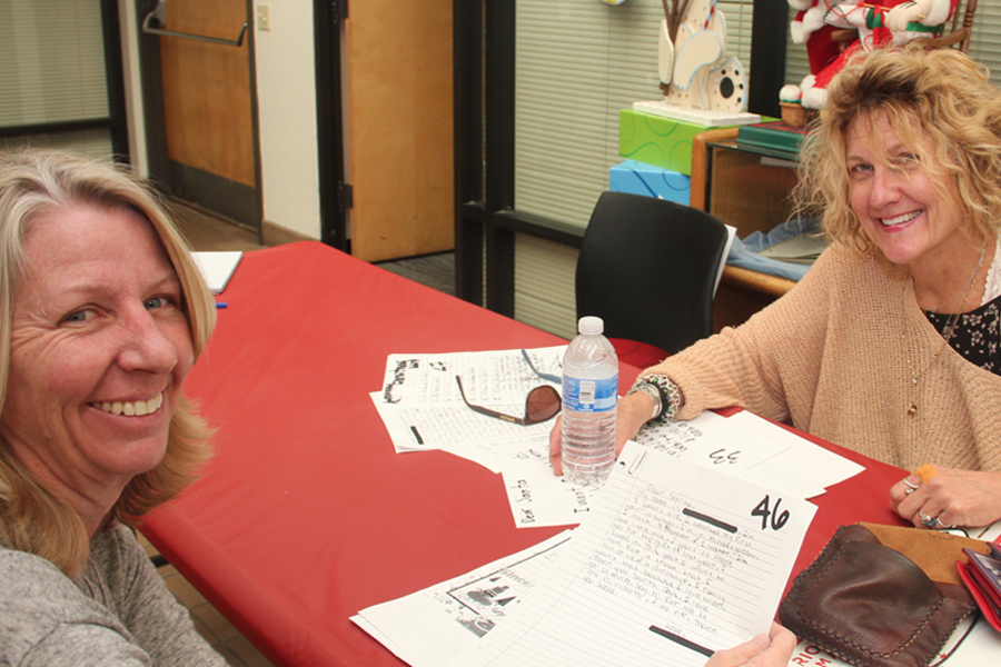 Customers Judy Brunelle and Paula Chambers review Operation Santa letters in Santa Ana District.