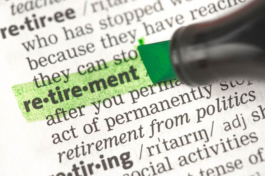 Someone highlighting the word: retirement on a page from the dictionary.