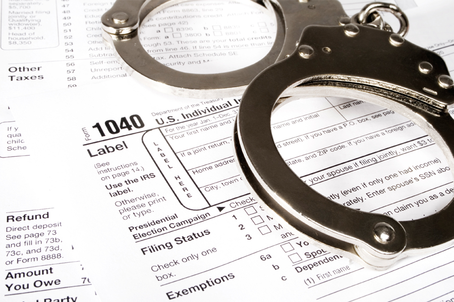 A pair of handcuffs on top of a 1040 tax form.