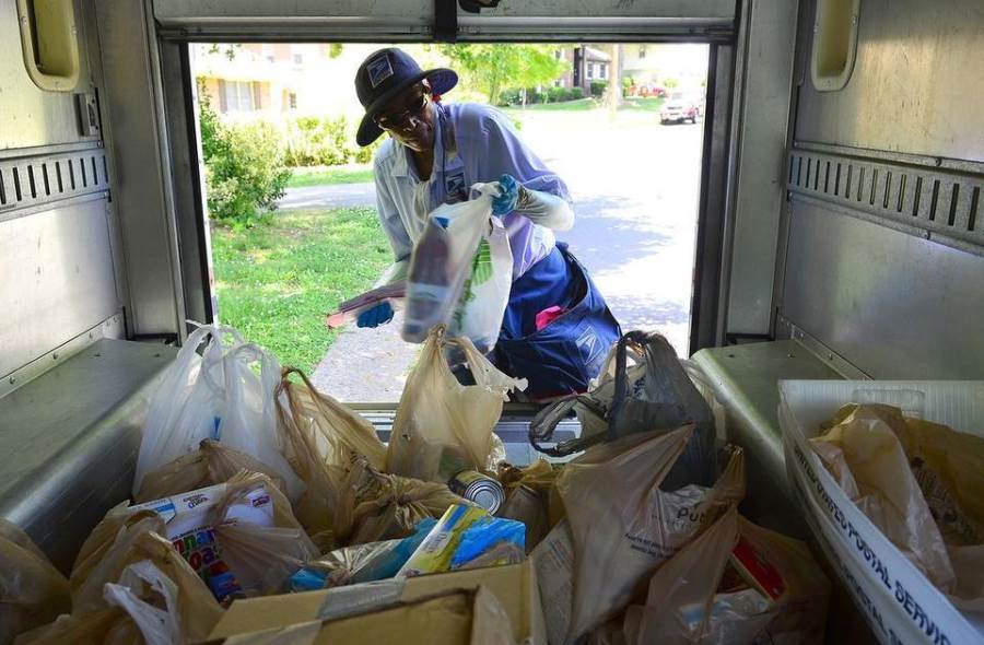 Letter carrier loading food donations
