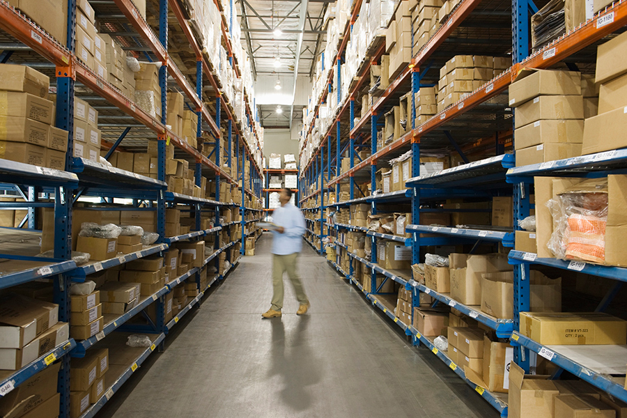 Man standing in warehouse aisle.