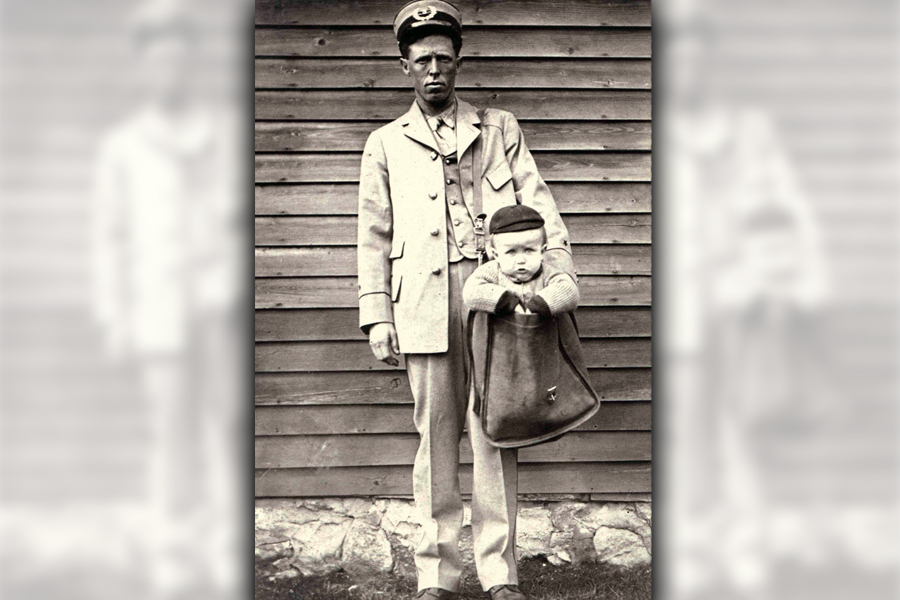 A letter carrier with a child in a mailbag. Image: National Postal Museum