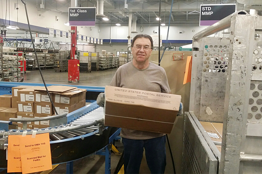 Sioux Falls, SD, Mail Processing Clerk Patrick Buchanan carries a tray of the retailer’s letters.