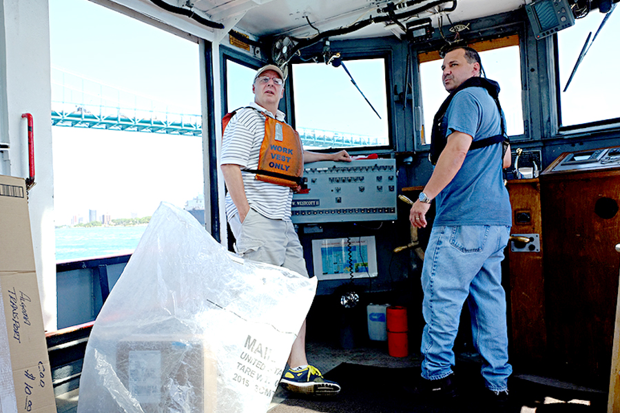 Bill Redding and Sam Buchanan take the boat out for a mail delivery on the Detroit River. Image: Atlas Obscura