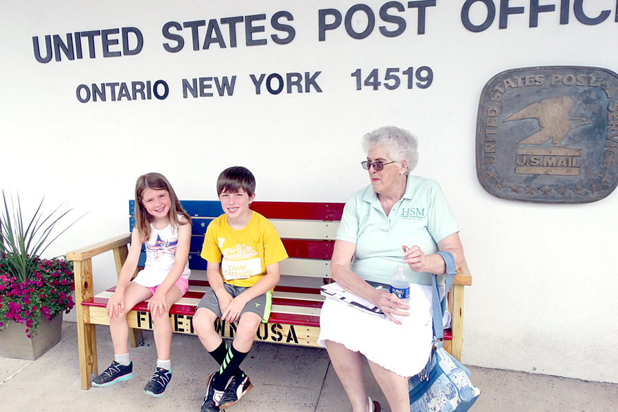 Ontario Post Office customers enjoy the new bench, which was hand-crafted by Custodian Phil Tallinger.