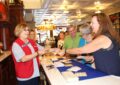 Columbus, IN, Retail Associate Sandy Smith, left, sells stamps to retired Butlersville, IN, Postmaster Anita Biehle.