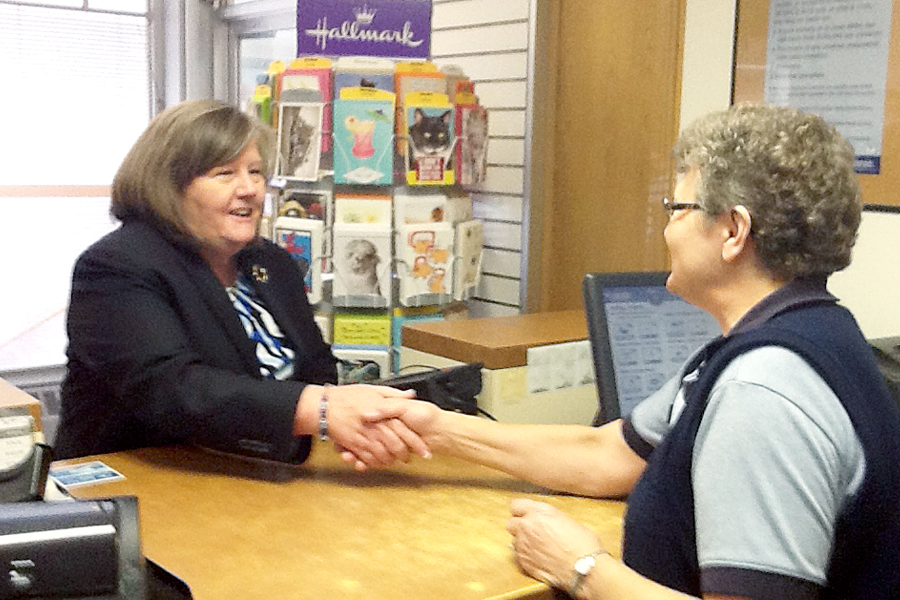 PMG Megan J. Brennan greets Retail Associate Deb Striefel during a visit to the Mandan, ND, Post Office last week.