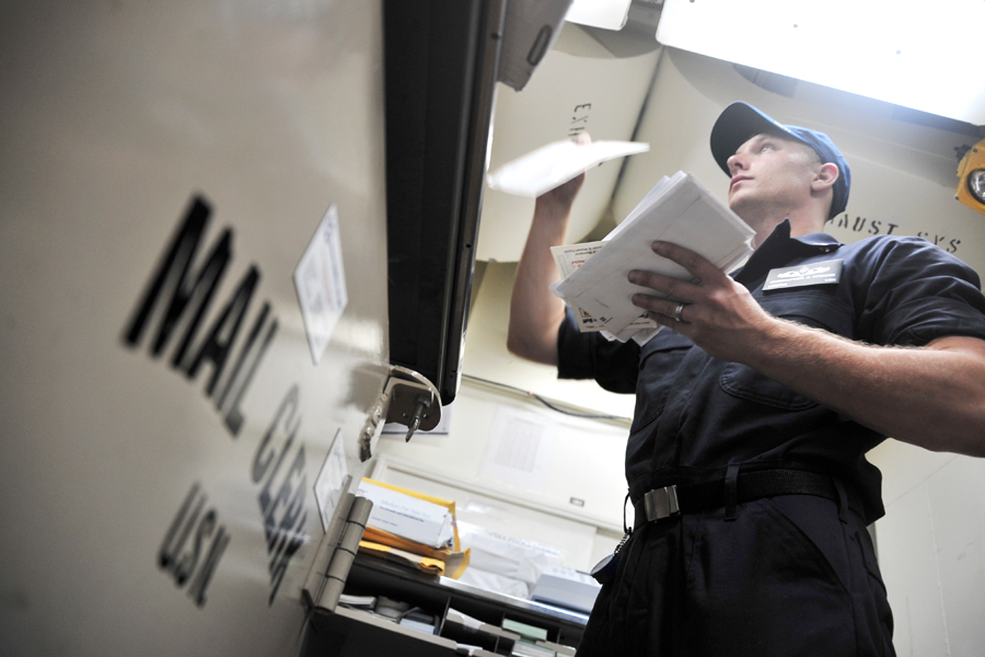 Logistics Specialist 2nd Class Christopher Younkin sorts mail aboard the USS Ross in 2014.