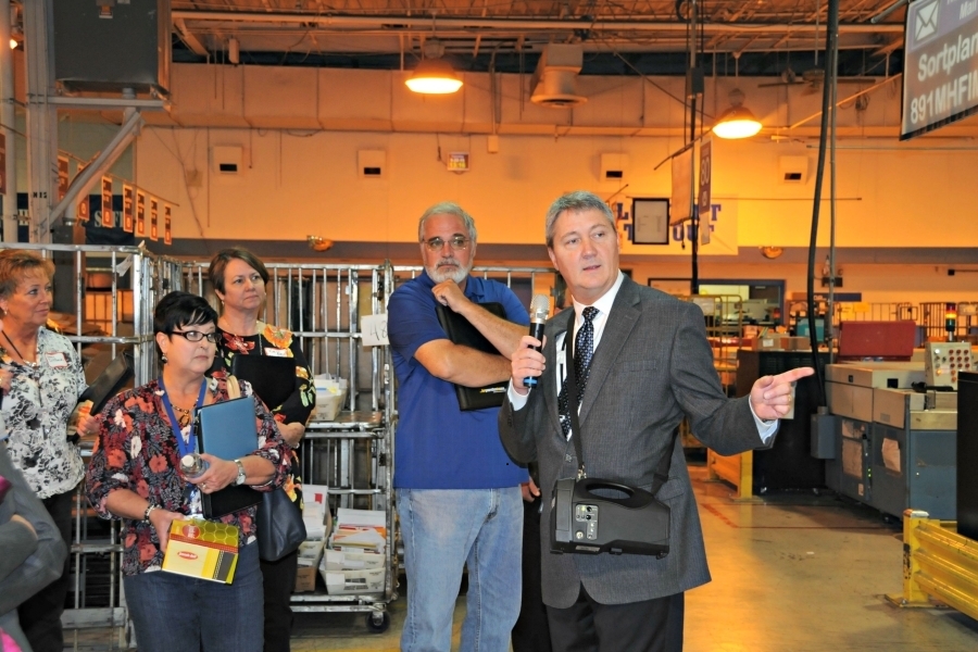 Maintenance Manager William Bartley leads business mailers on a tour of the Louisville, KY, Processing and Distribution Center during last year’s National PCC Week.