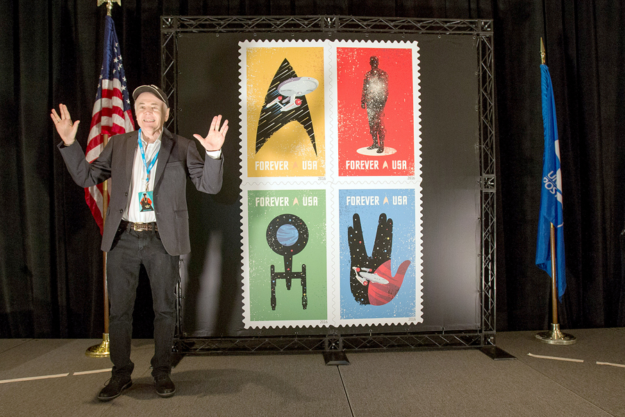 Walter Koenig, who portrayed Pavel Chekov on “Star Trek,” poses in front of a stamp display at the ceremony.