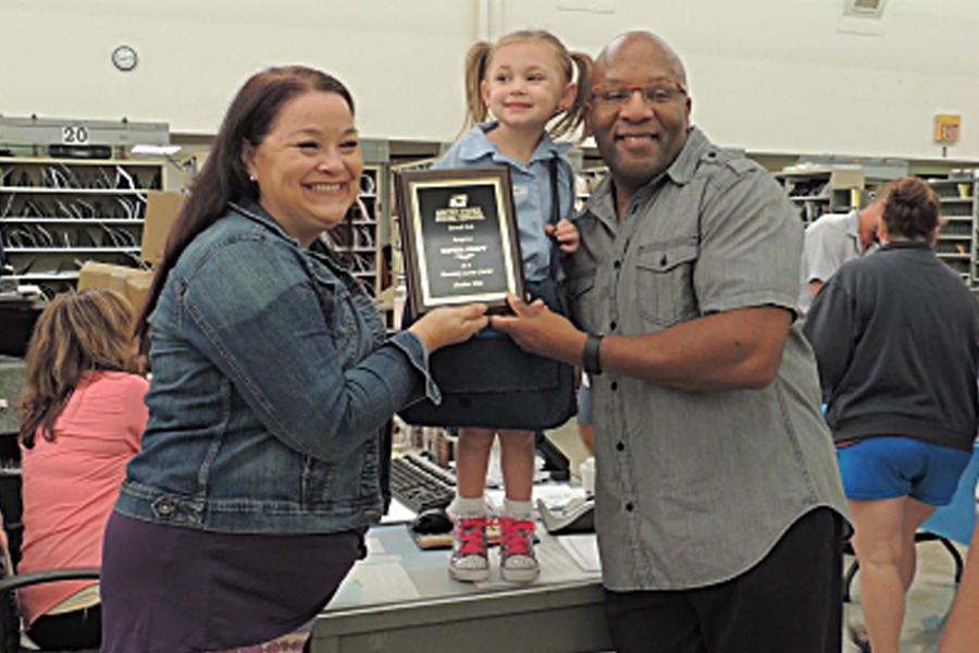Jennifer Kraft and her daughter, Sophia, and husband, Kory, show off Sophia’s honorary letter carrier plaque last week. Image: Courier-Post
