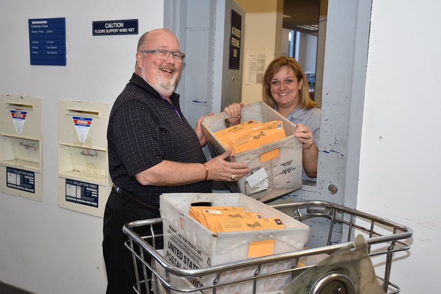 Chris Carithers, an election commissioner in Douglas County, NE, picks up Election Mail from Omaha Retail Associate Lisa Pudys last week.