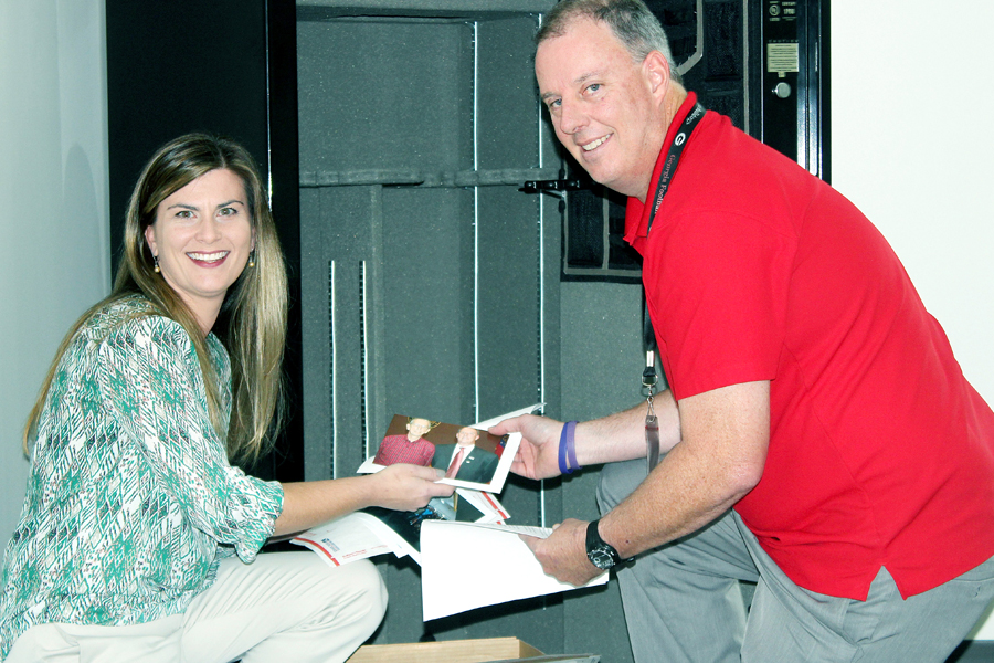 Nikki Perry, Lilburn’s city hall public relations manager, and Postmaster David Hinesley add items to the time capsule.