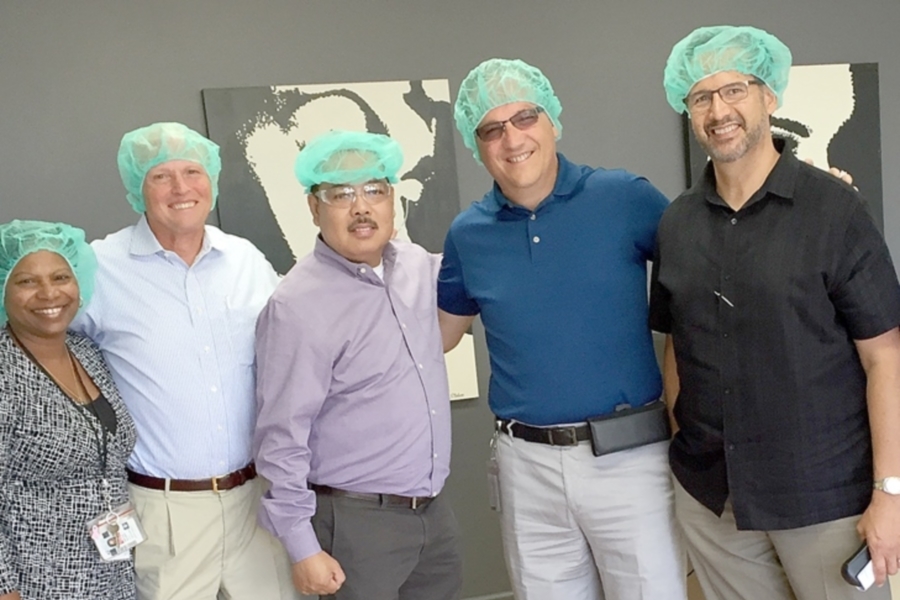 The Pacific Area team members who worked on the sale don hairnets during a visit to the cosmetics company. Shown, from left, are Santa Clarita Processing and Distribution Center Acting Plant Manager Daphne Glaspie, Enterprise Accounts Director Jim O’Brien, Sierra Coastal District Manager Larry Munoz, VP Dean Granholm and Strategic Accounts Manager Richard Rodriguez.
