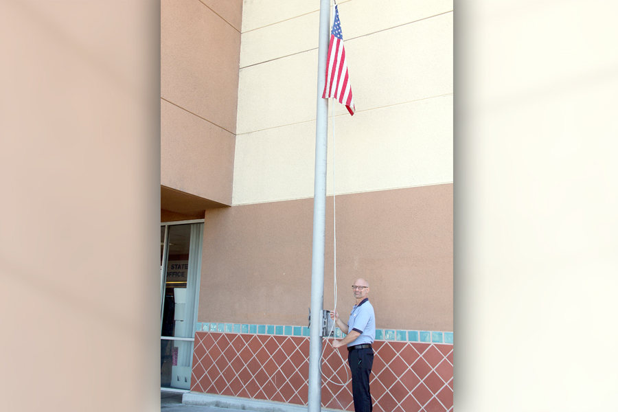 Retail Associate Nick DePierola raises the flag recently at Westminster Station in Santa Ana, CA.