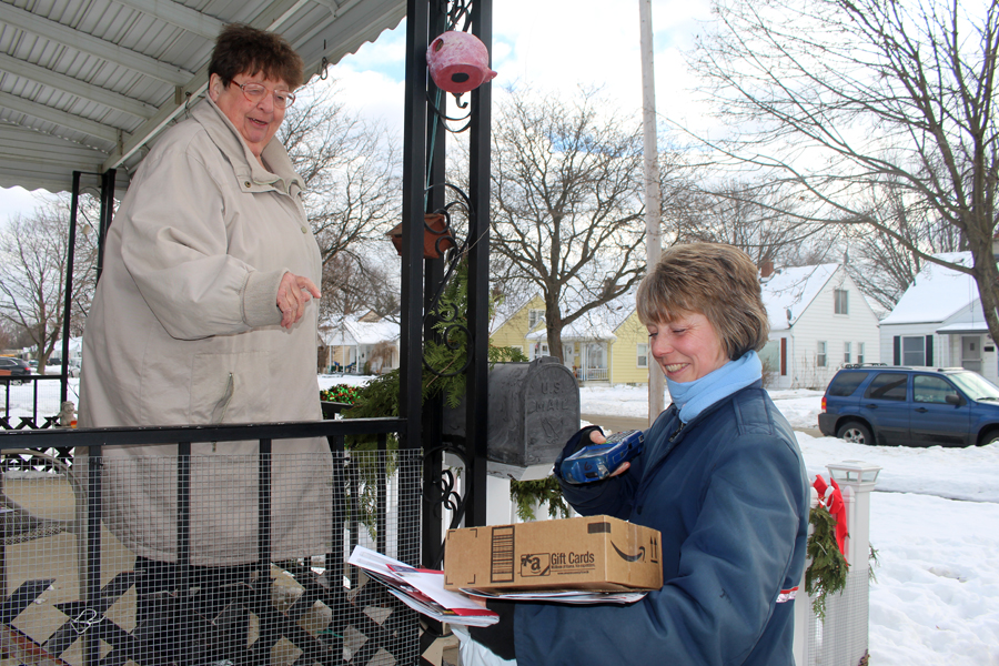 Customer Linda Karinen receives a package from Garden City, MI, Letter Carrier Andrea Tomlin Dec. 22, which was expected to be the year’s busiest delivery day.