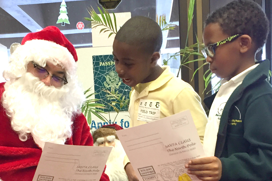 Santa Claus reviews letters with help from local schoolchildren at the Oakland, CA, Main Post Office, one of several USPS sites that held Operation Santa kickoff events this week.