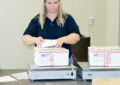 Saginaw, MI, Postmaster Carrier Downing prepares care packages recently.