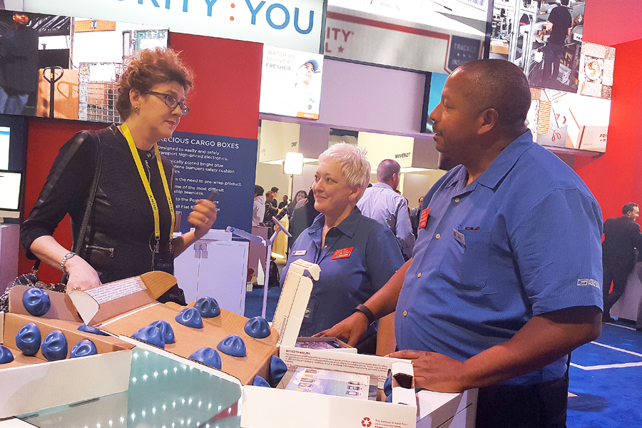 Trade show attendee talks to postal employees