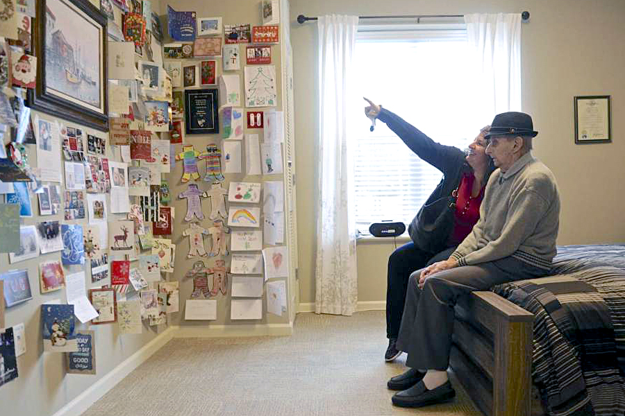 USPS retiree James Gaboardi sits in his room in his nursing home with his granddaughter Meghan Henriques-Parker, looking at the cards that have been sent to him. Image: Hearst Connecticut Media