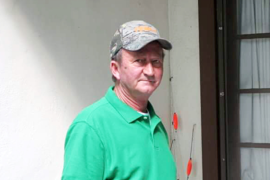 Rural Carrier Roger Burnette wearing a green shirt and baseball hat