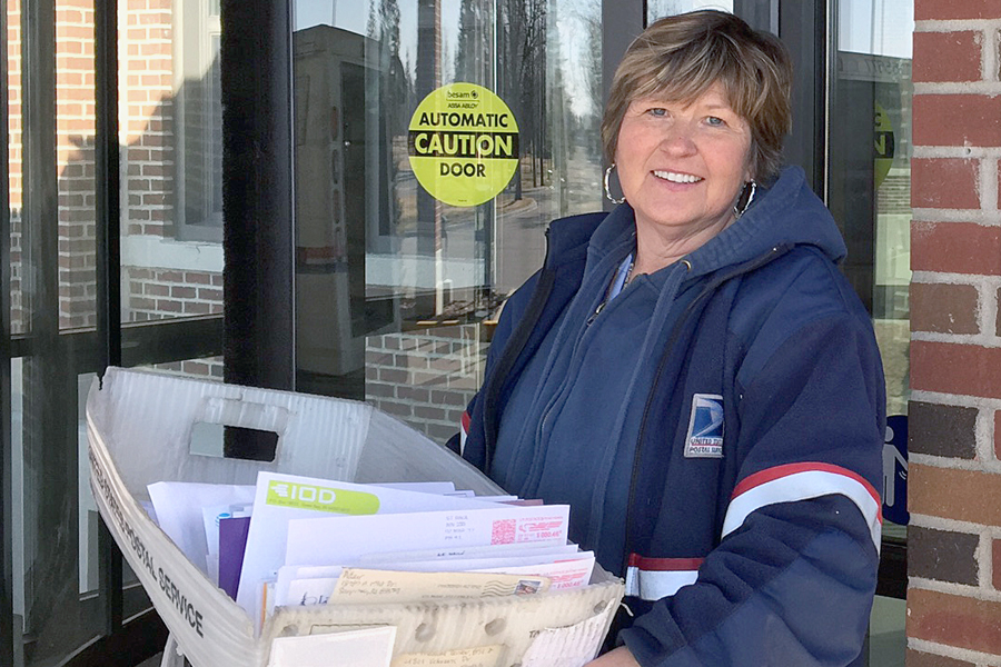 Female letter carrier delivers mail
