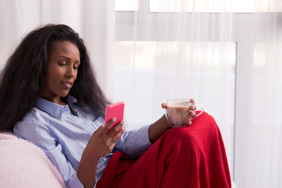 Woman with red blanket looks at phone