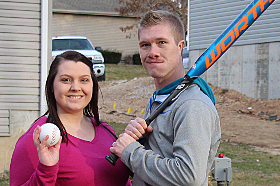 Expectant parents holding ball and bat