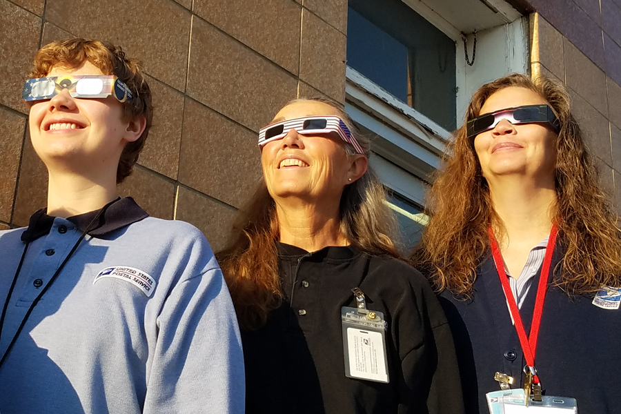 USPS employees wear special glasses and watch eclipse