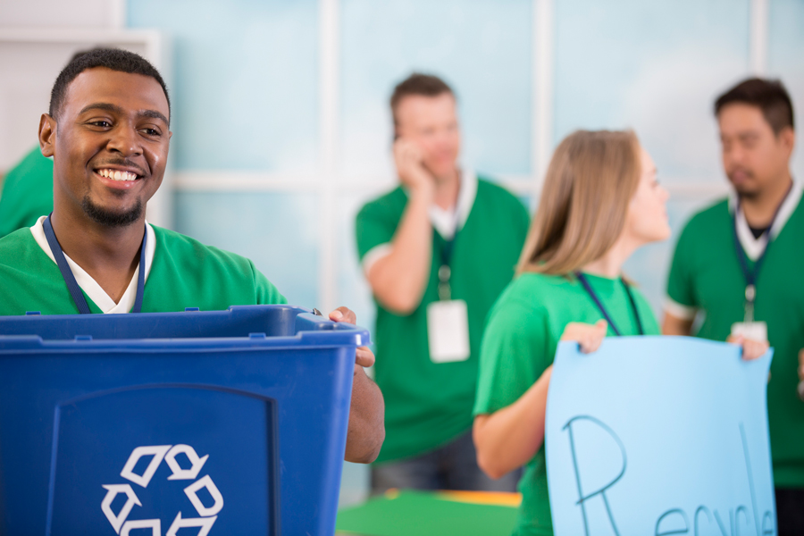 Employees in green shirts recycling