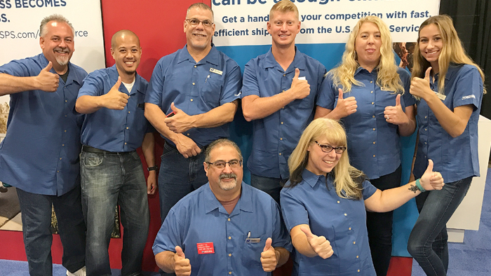 Employees in blue shirts pose