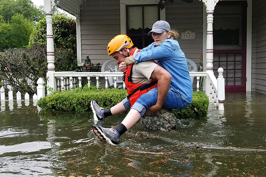 National Guard soldier carries woman on back through flooded waters