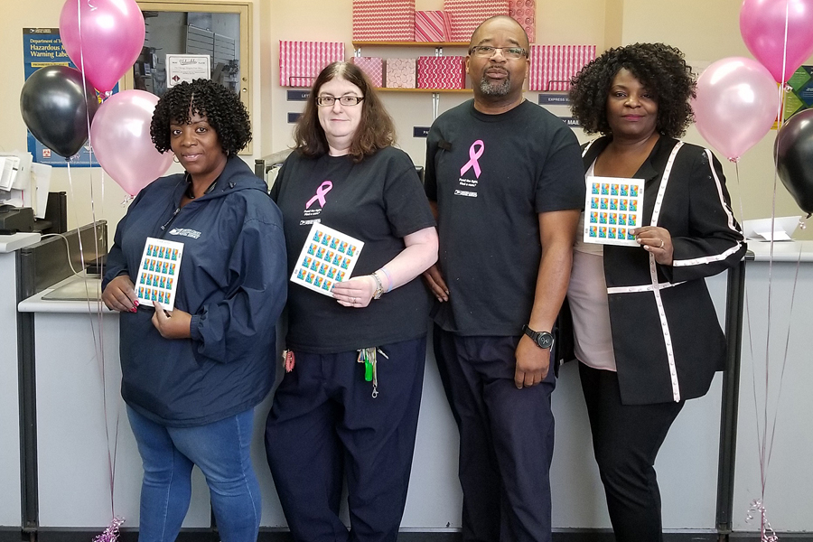 Employees at the Chicago Heights, IL, Post Office display Breast Cancer Research stamps.