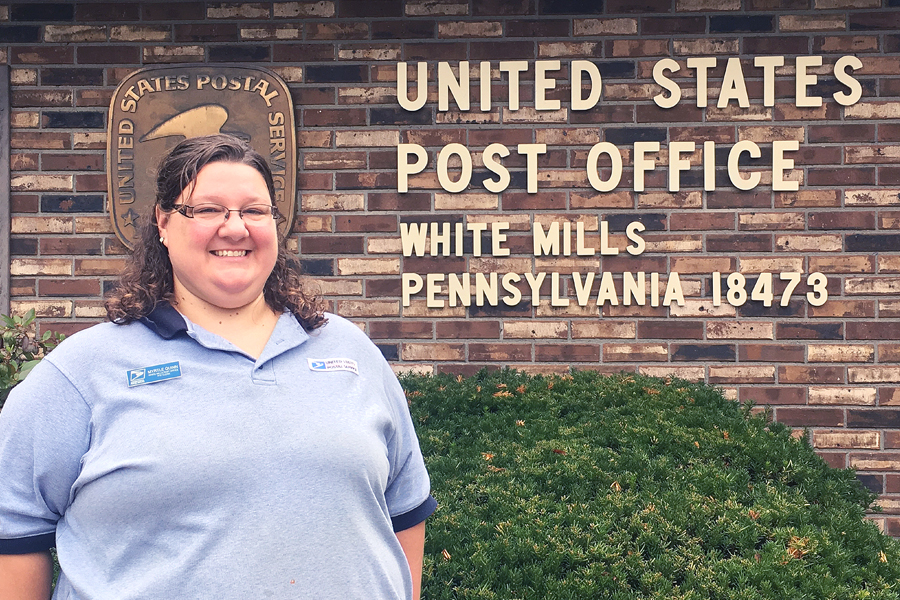 USPS employee standing in front of Post Office