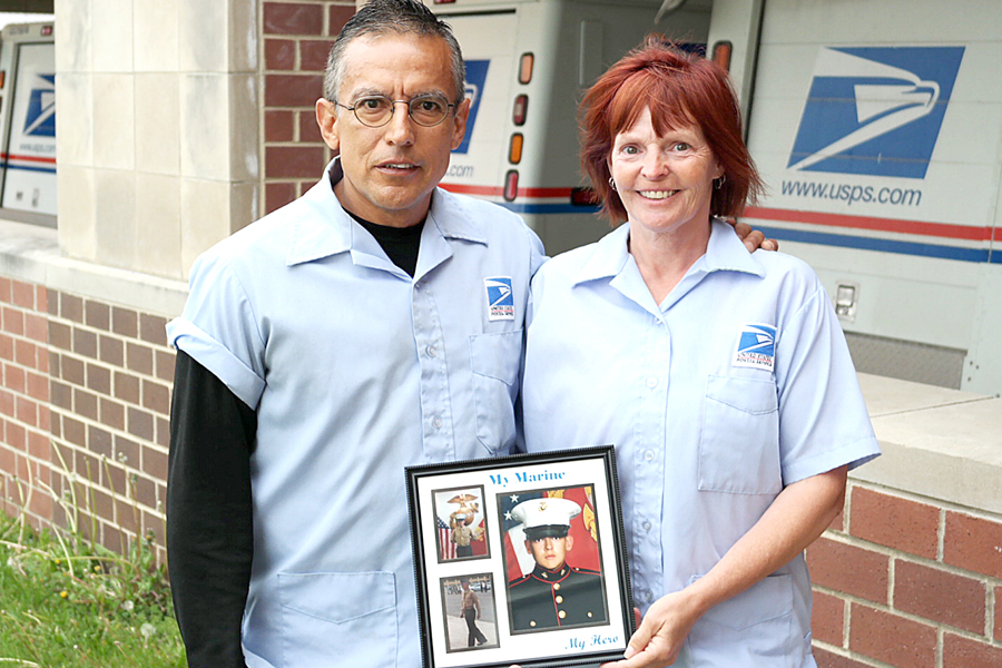 Man and woman hold photo of marine