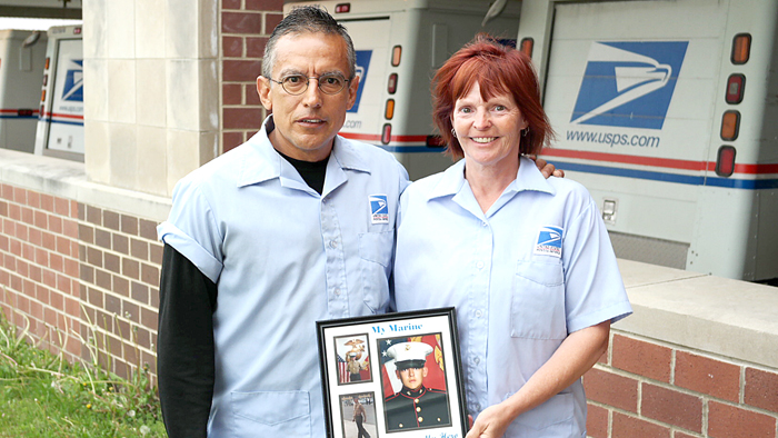 Man and woman hold picture of marine