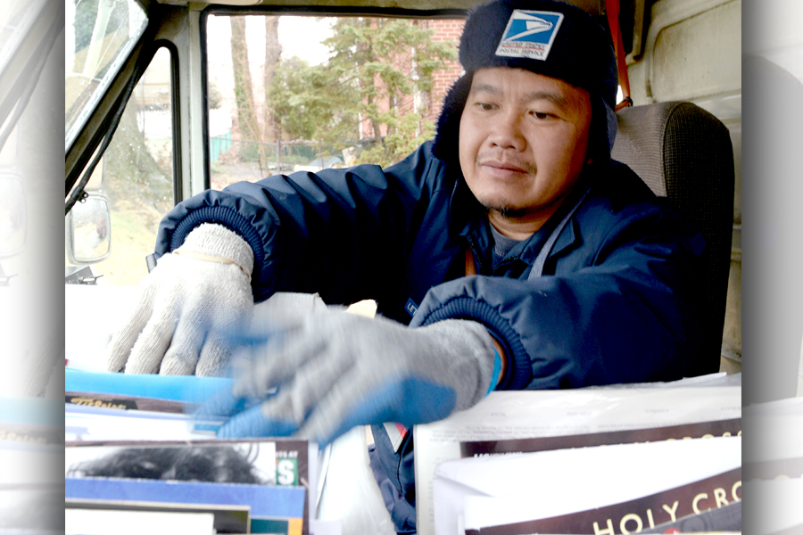 Letter carrier handles mail inside delivery vehicle