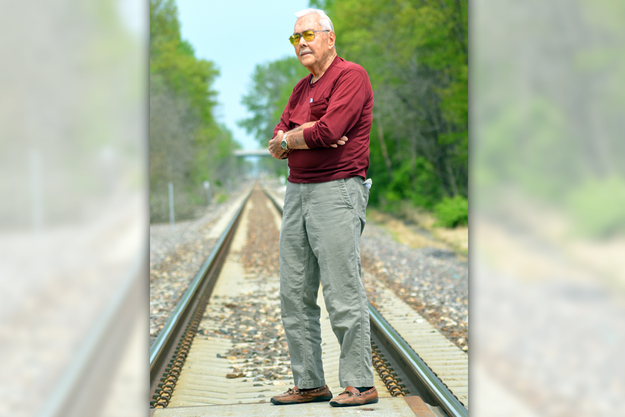 Older man standing near railroad tracks