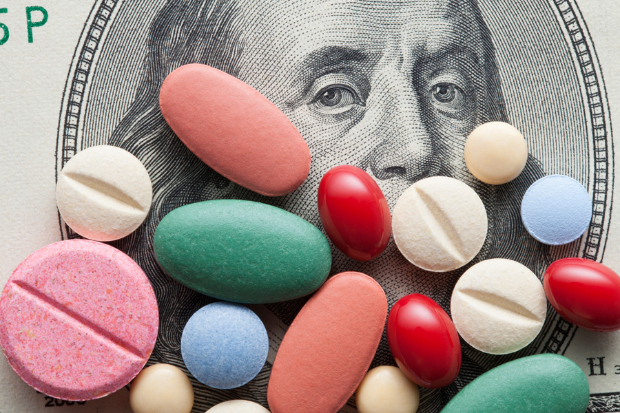 Colorful pills over a Ben Franklin bill