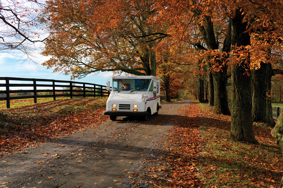 Postal LLV driving through fall scenery