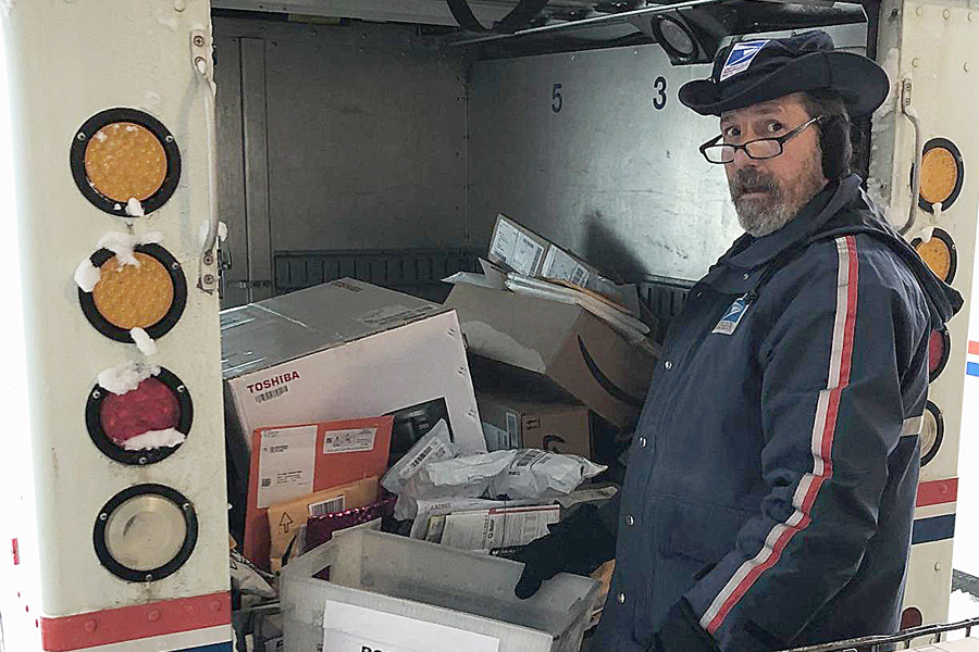 Postal worker loads delivery vehicle